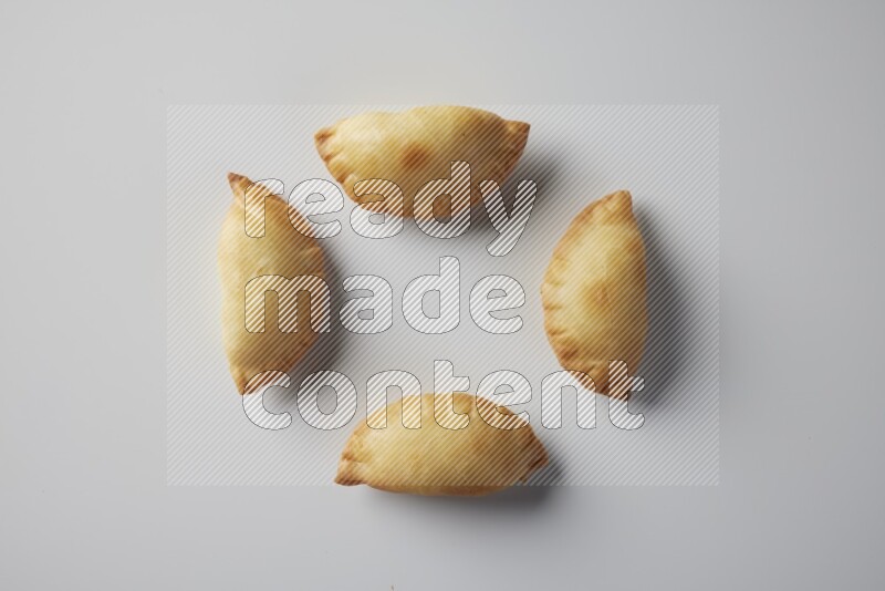 Four fried sambosa from a top angle on a white background
