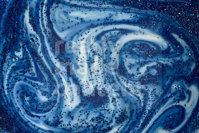 A close-up of sparkling blue glitter scattered on swirling blue and white background