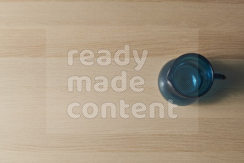 إبريق زجاجي فارغ على خلفية خشبية فاتحة