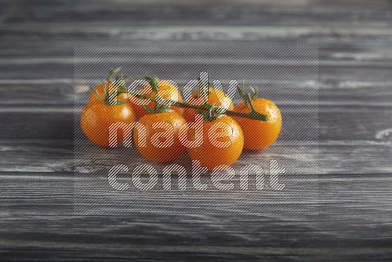orange cherry tomato vein on a textured grey wooden background 45 degree