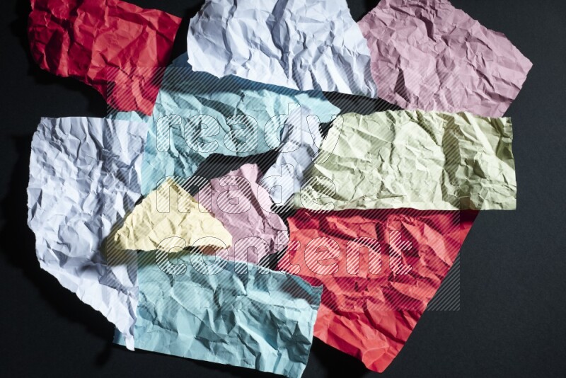Crumpled multicolored paper on black background