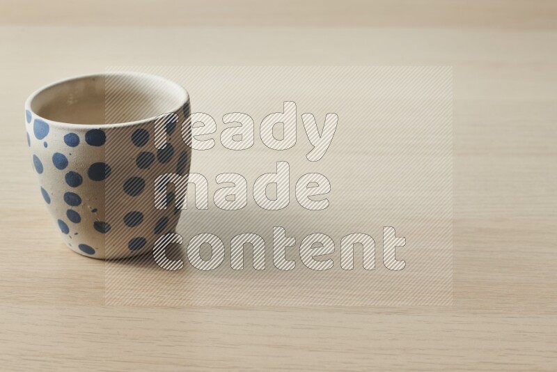 A pottery cup on light wooden background