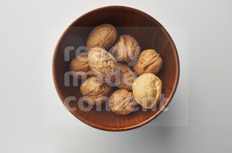 Top-view shot of walnut in a container on white background