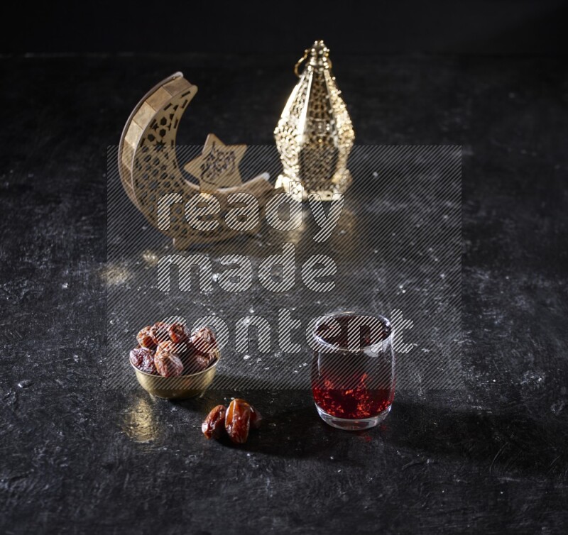 Dates in a metal bowl with Hibiscus beside golden lanterns in a dark setup