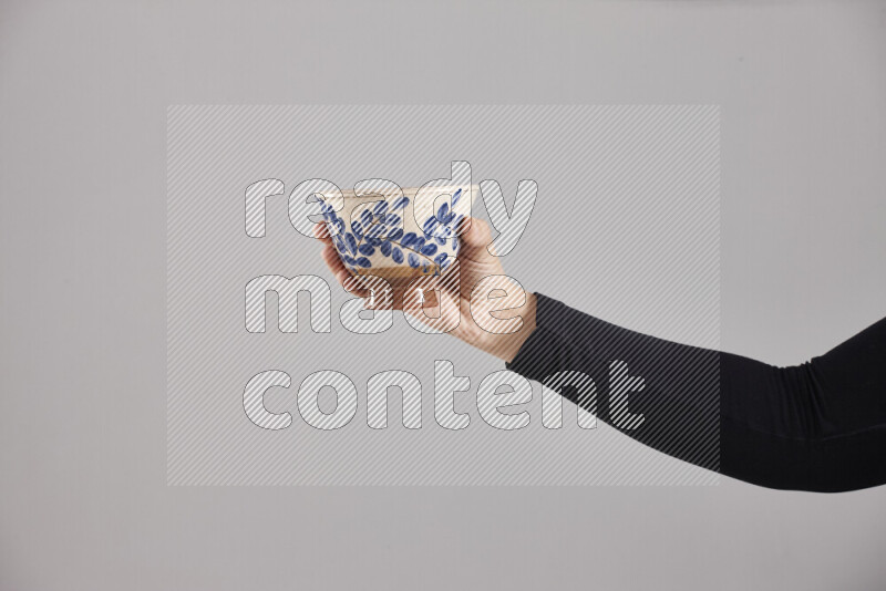A woman in black abaya holding different pottery essentials in different positions