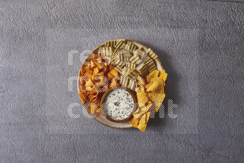 Assorted snacks in pottery bowls on grey background