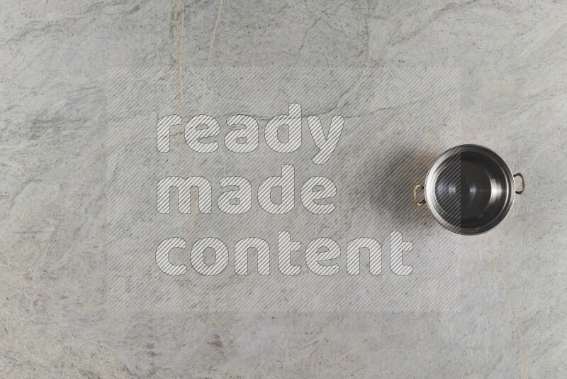 A small copper pot on grey marble background