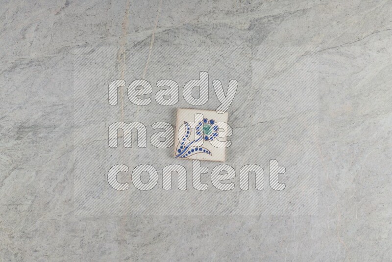A decorative pottery coaster on grey marble background