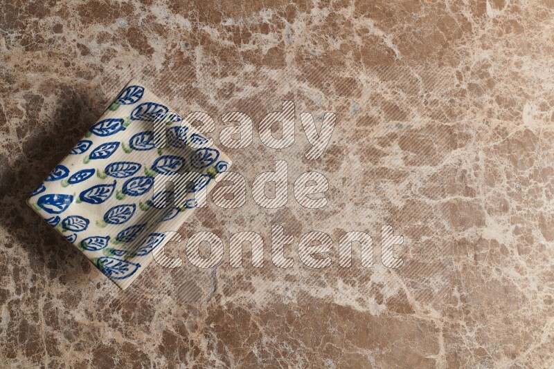 A decorative pottery plate on beige marble background