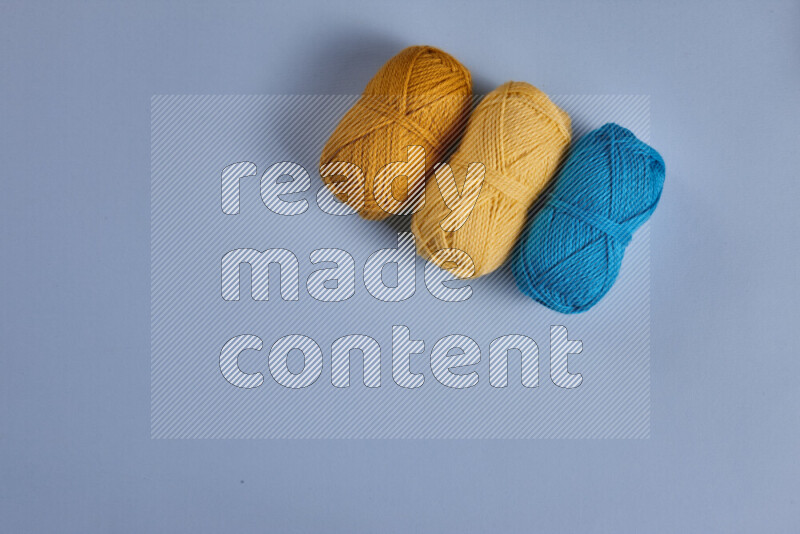 مجموعة من أدوات الخياطة والتفصيل صفراء وزرقاء اللون على خلفية زرقاء