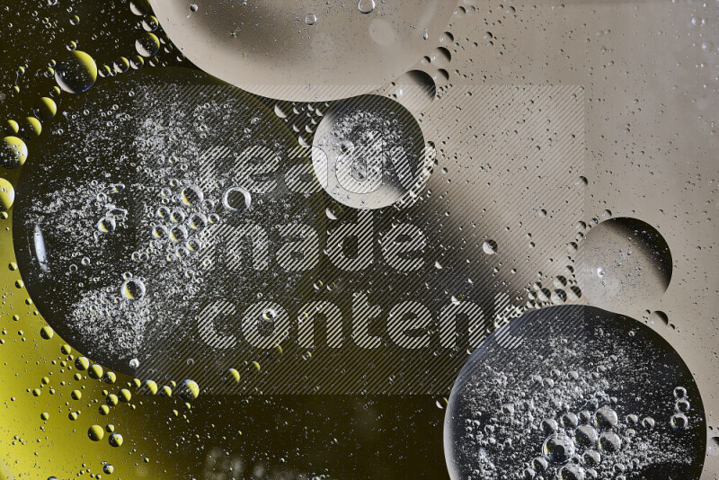 Close-ups of abstract oil bubbles on water surface in shades of brown, black and yellow