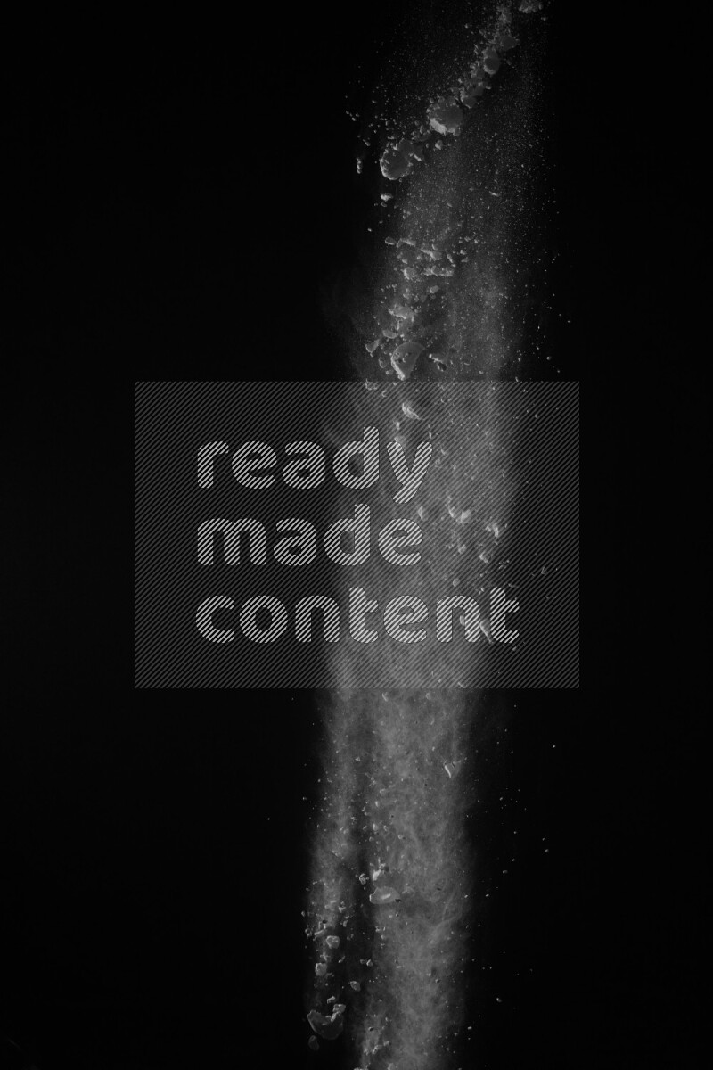 A side view of white powder explosion on black background