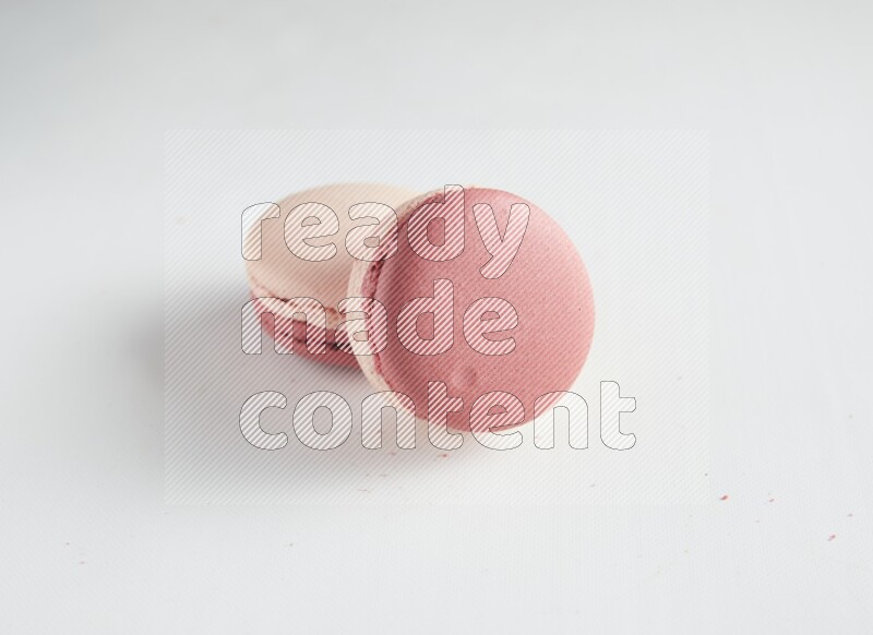 45º Shot of two Pink Litchi Raspberry macarons on white background