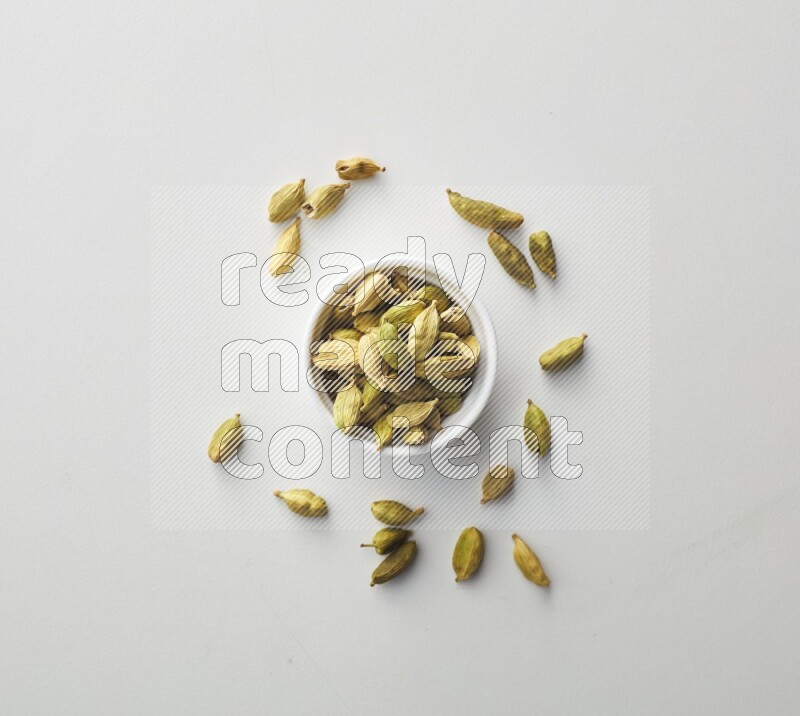 Top-view shot of Cardamon in a container on white background