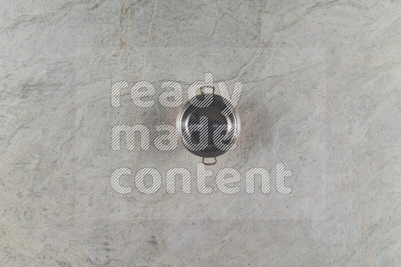 A small copper pot on grey marble background