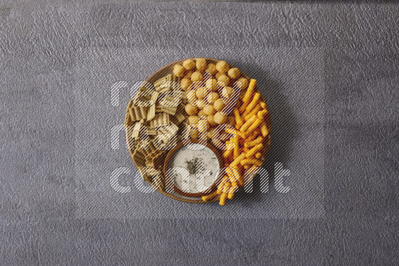 Assorted snacks in pottery bowls on grey background
