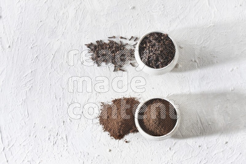 وعاءين من السيراميك بيج اللون، أحدهما مملوء بالقرنفل والآخر مملوء بالبودرة على أرضية بيضاء