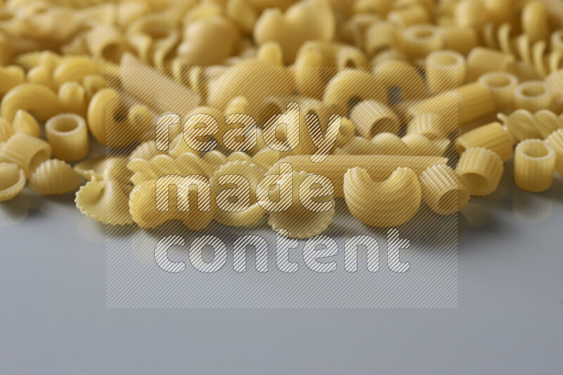 Different pasta types on light blue background