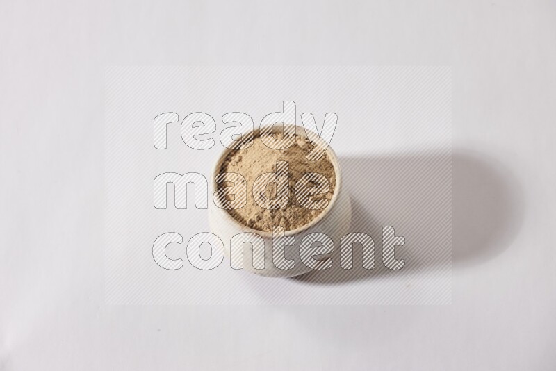 وعاء فخاري بيج ممتلئ ببودرة الثوم علي خلفية بيضاء