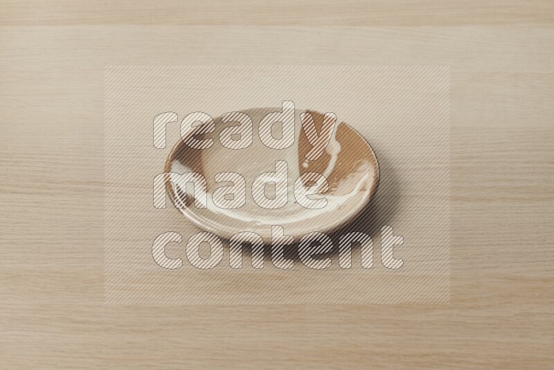 A beige pottery plate on light wooden background