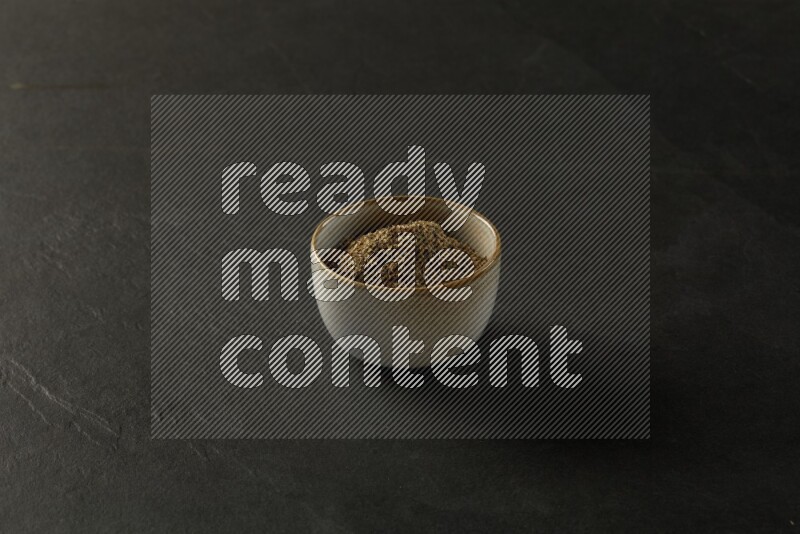 multi color round sauce bowl filled with herbs on grey textured countertop