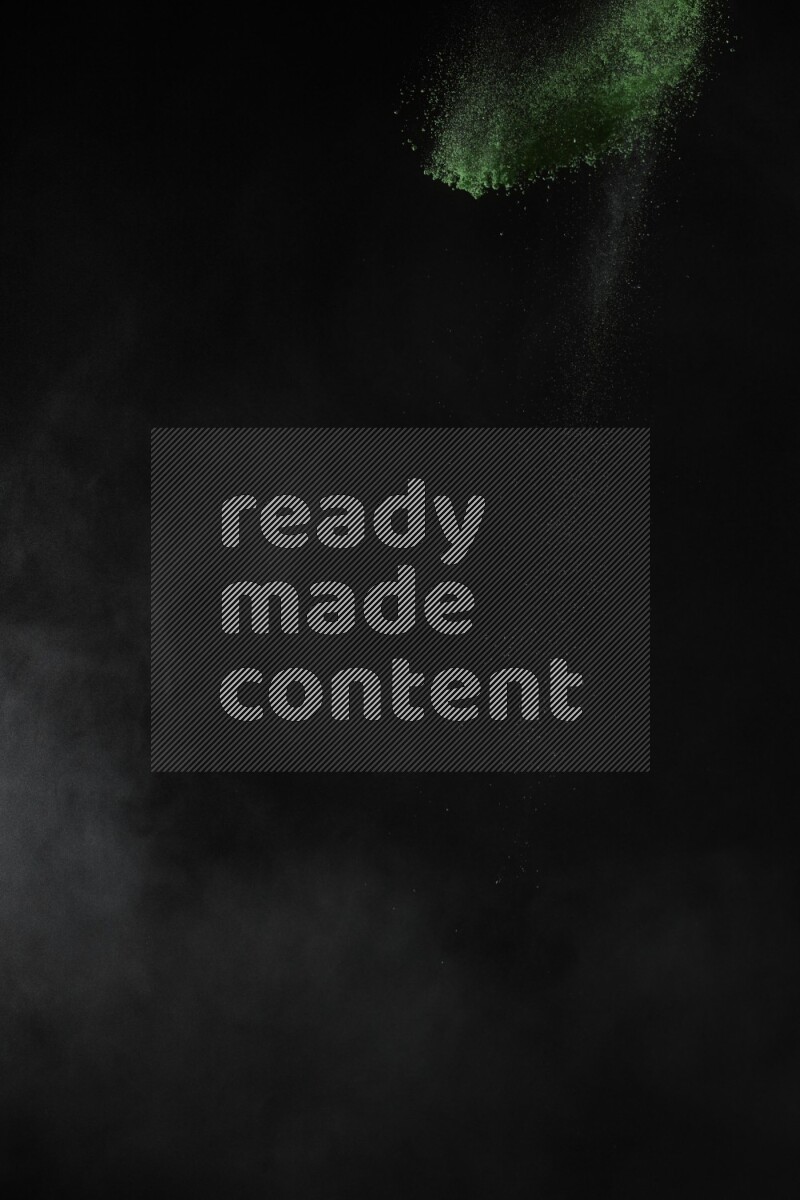 A side view of green powder explosion on black background