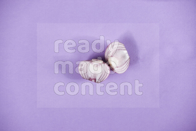 Halves red onions on a purple background