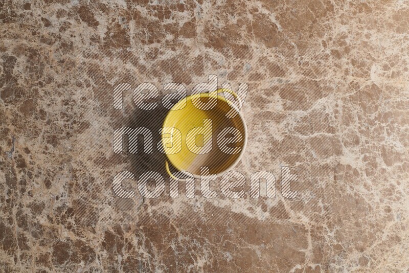 A multicolored pottery bowl on beige marble background