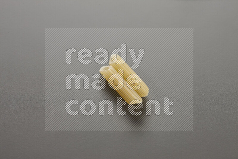Mini penne pasta on grey background