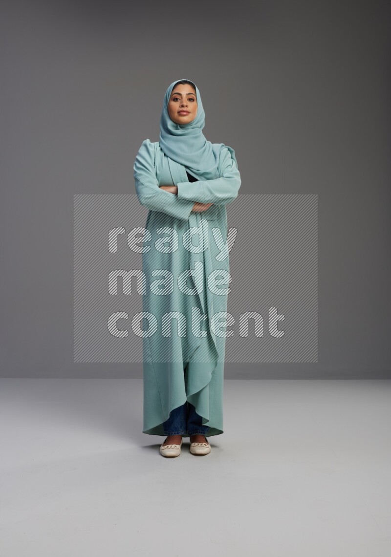 Saudi Woman wearing Abaya standing with crossed arms on Gray background