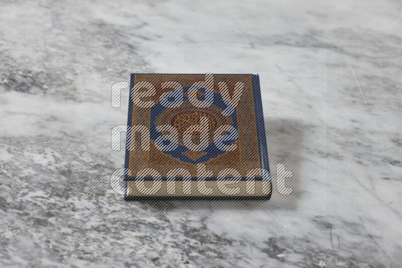 Quran with a prayer beads on grey marble background