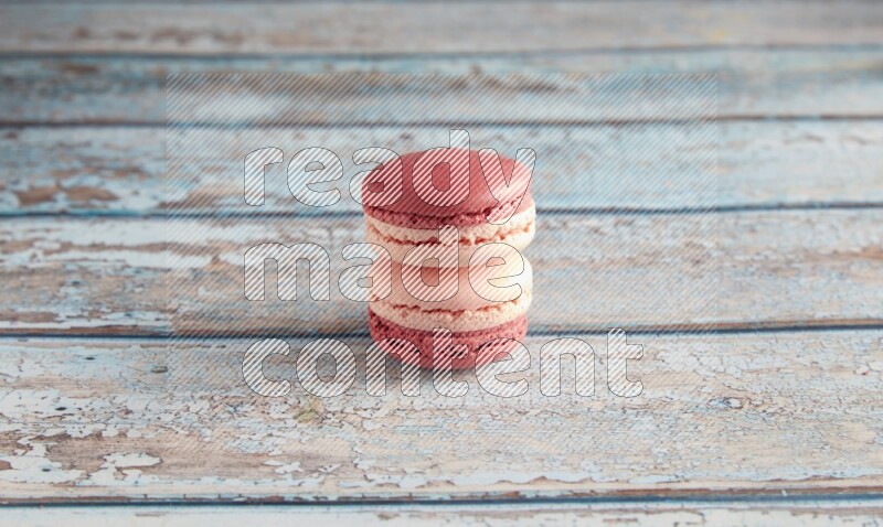 45º Shot of two Pink Litchi Raspberry macarons on light blue wooden background