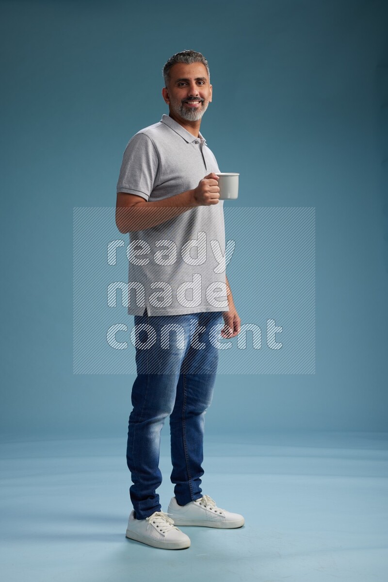 Man Standing drinking coffee on blue background