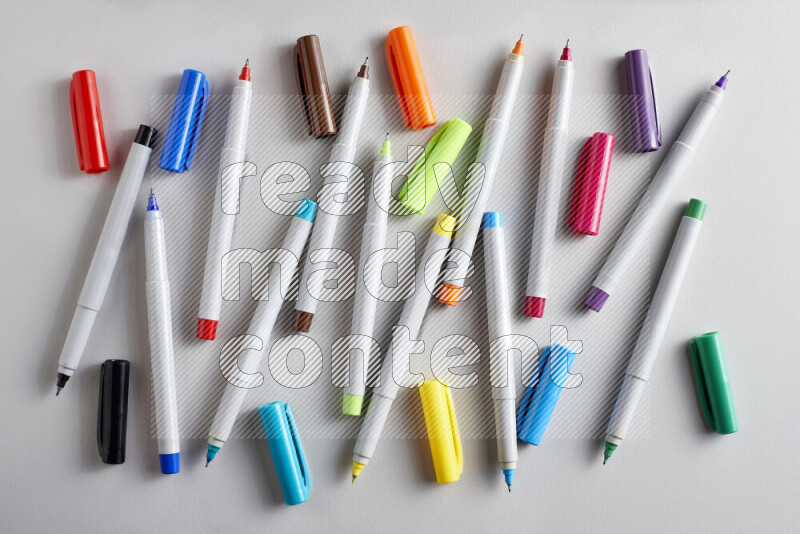 An arrangement of coloring pens in different colors on grey background