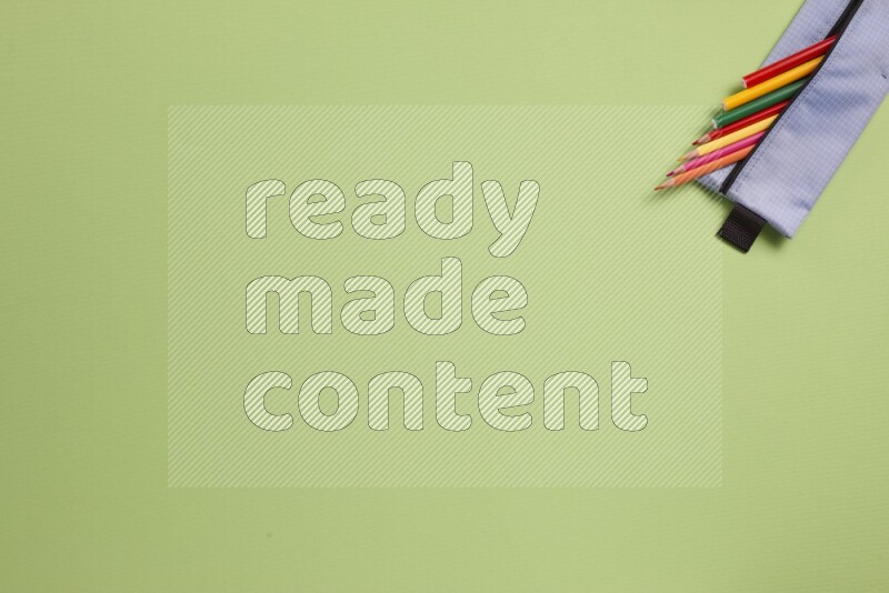 Different school supplies on green background