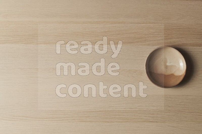 A beige pottery plate on light wooden background