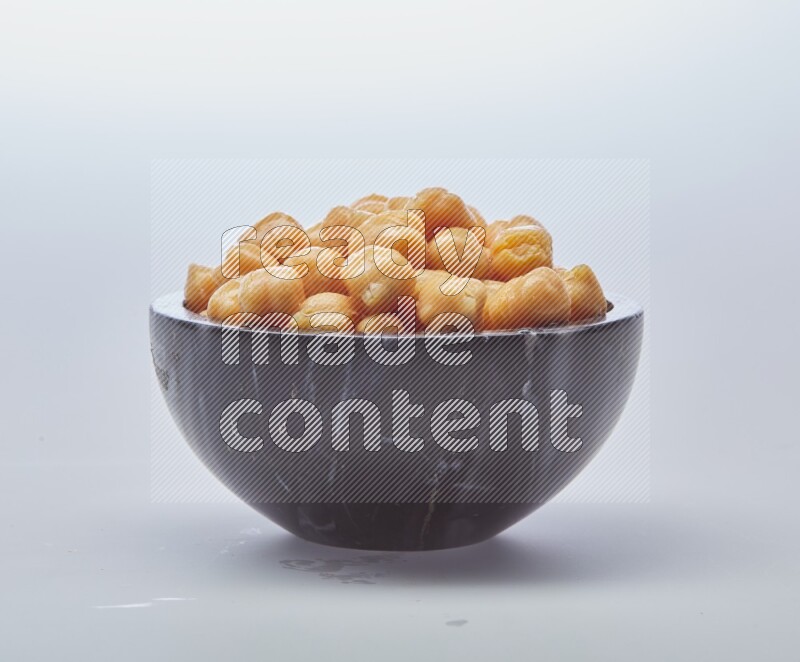 Close up of a boiled chickpeas in a container on white background