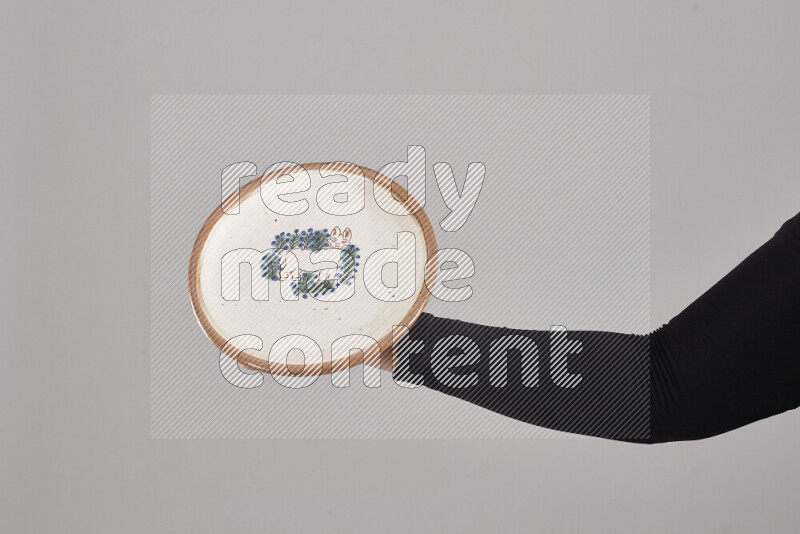 A woman in black abaya holding different pottery essentials in different positions