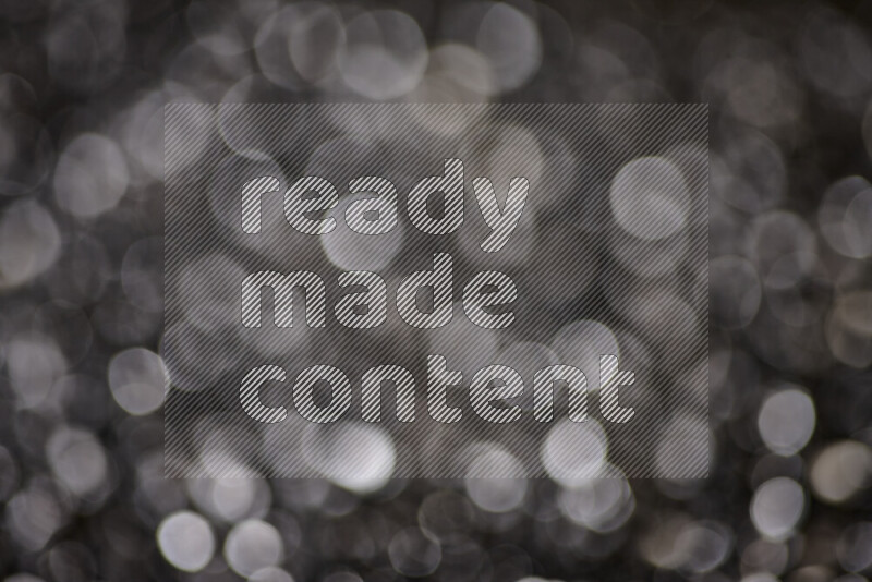 Black shimmering fragments of glass scattered on a black background