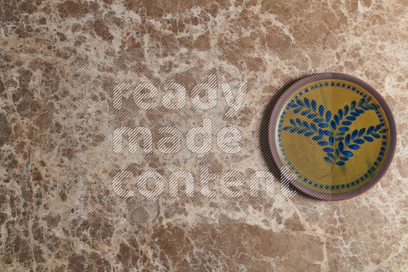 A decorative pottery plate on beige marble background