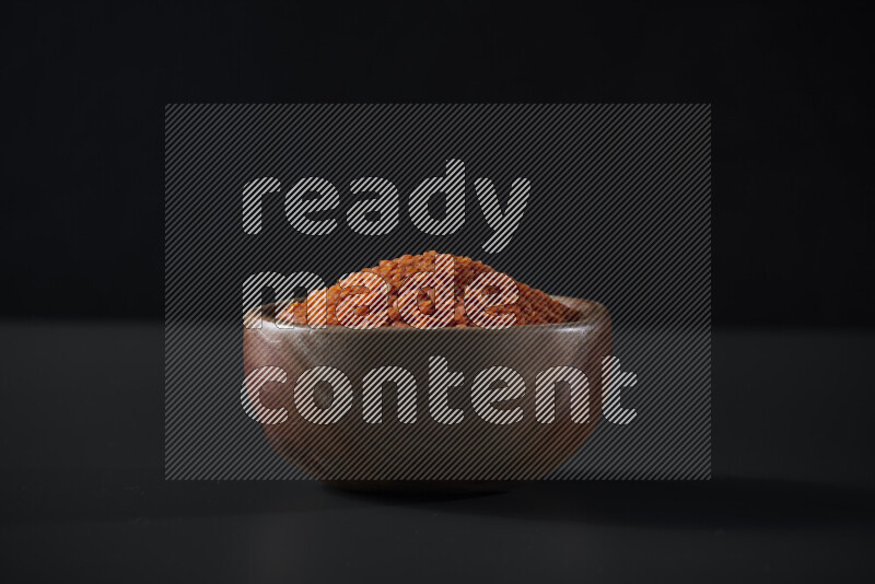 Lentils in a wooden bowl on grey background