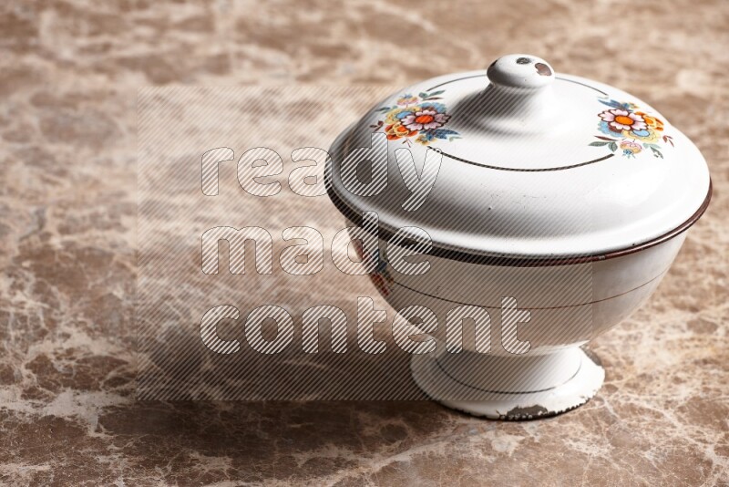 A vintage metal bowl on beige marble background