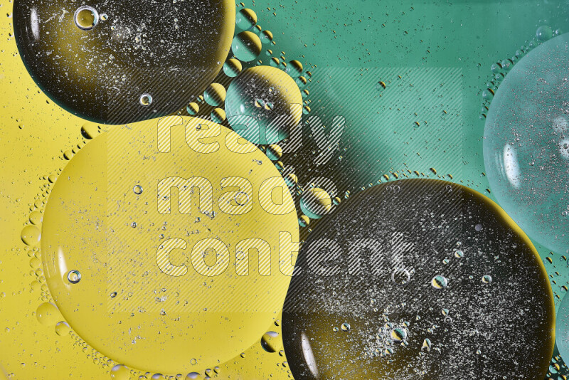 Close-ups of abstract oil bubbles on water surface in shades of green and yellow