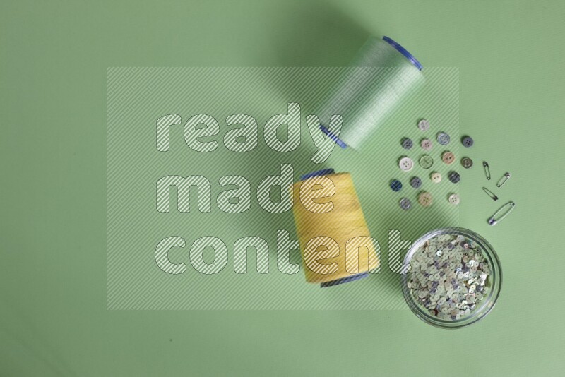 مجموعة من أدوات الخياطة والتفصيل على خلفية خضراء