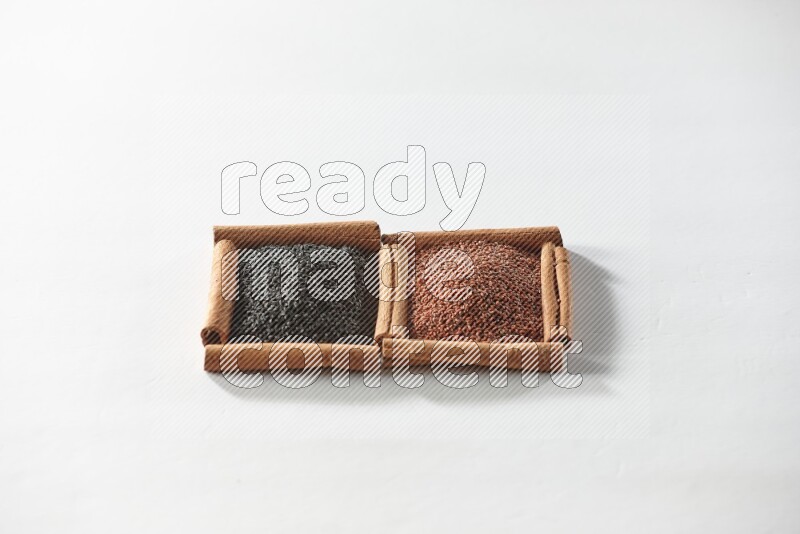 2 squares of cinnamon sticks full of black seeds and garden cress on white flooring