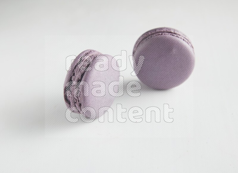 45º Shot of two Purple Blueberry macarons on white background