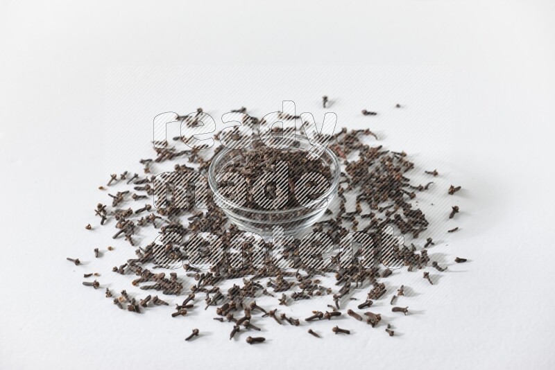 A glass bowl full of cloves on a white flooring