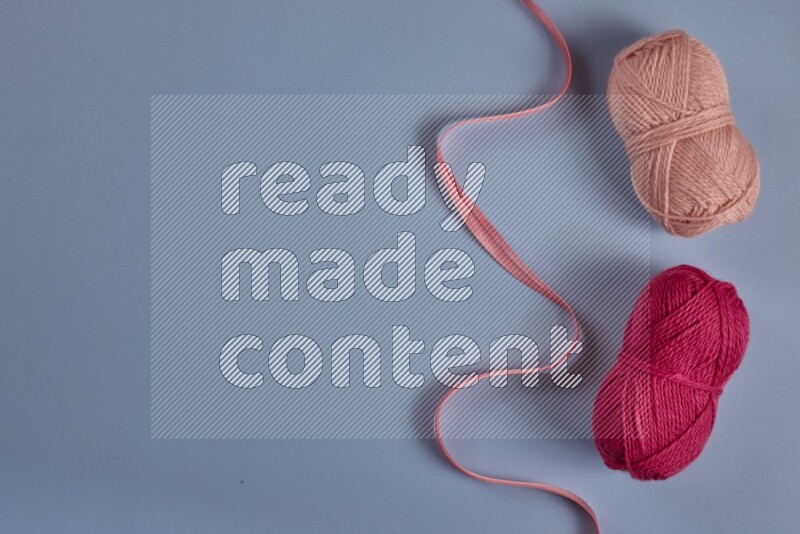 مجموعة من أدوات الخياطة والتفصيل زهرية اللون على خلفية زرقاء