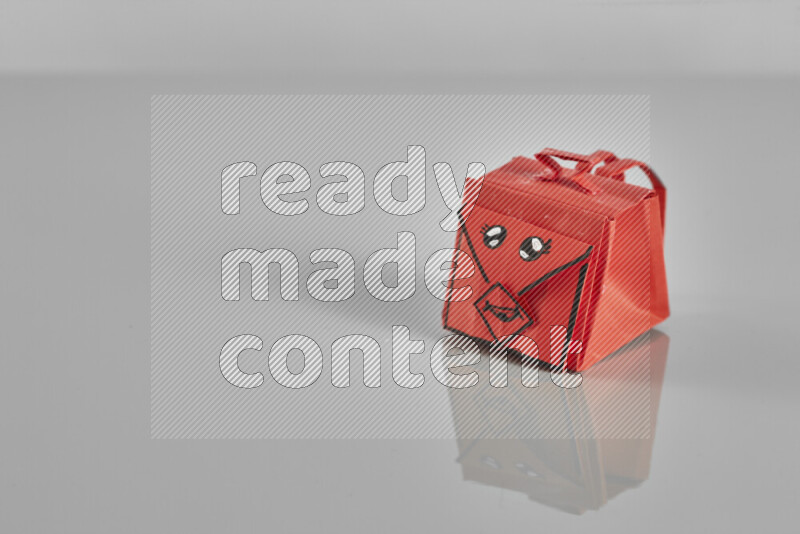 Origami school supplies such as back bag, books and ruler on grey background