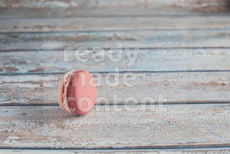 45º Shot of Pink Litchi Raspberry macaron on light blue wooden background